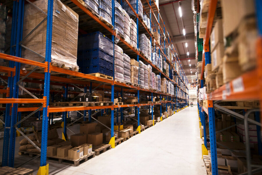 interior de grande armazém de distribuição com prateleiras repletas de paletas e produtos prontos