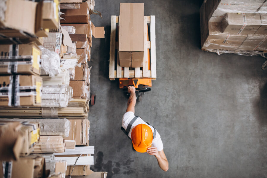 young man working at a warehouse with boxes supply chain